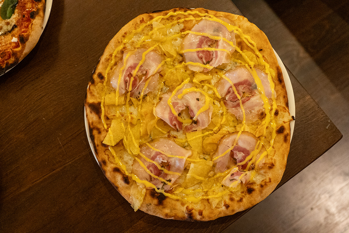 Pizza de Porchetta con patatas chips y allioli en ROMO Barcelona