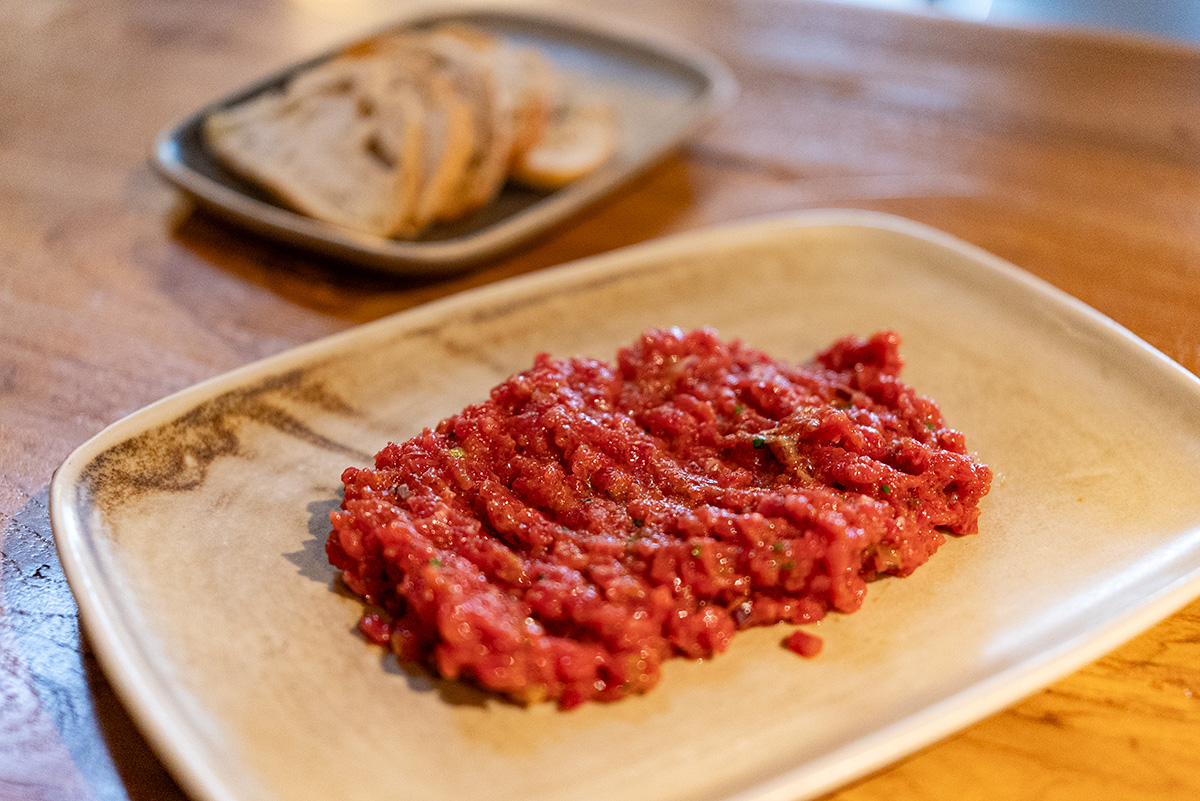 Steak tartar mezclado y servido en mesa en Finca Nebot 1924, Barcelona
